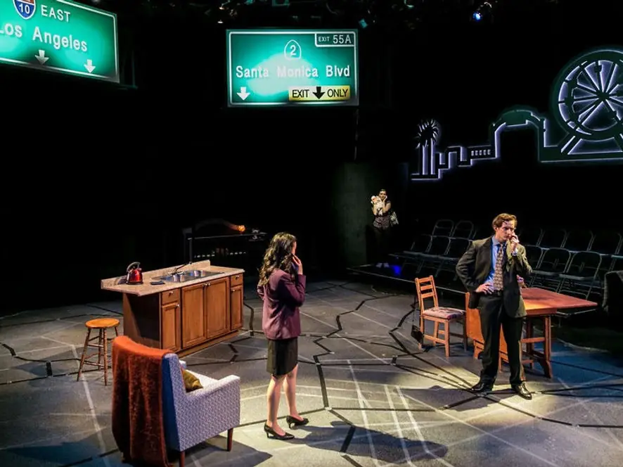 Production photo from Living Out showing performers in Gretchen Ugalde's Los Angeles-inspired scenic environment.